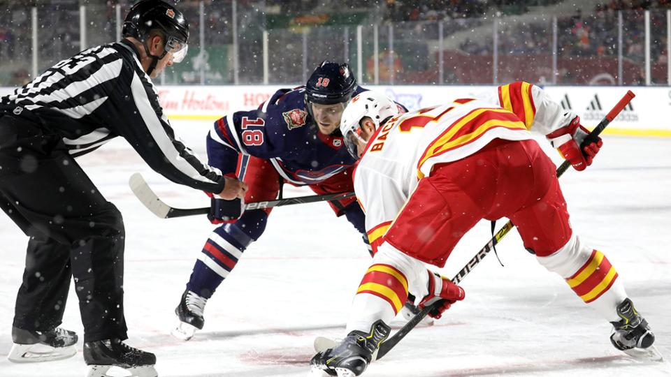 Bryan Little e Mikael Backlund enquanto aguardam o juiz liberar o puck